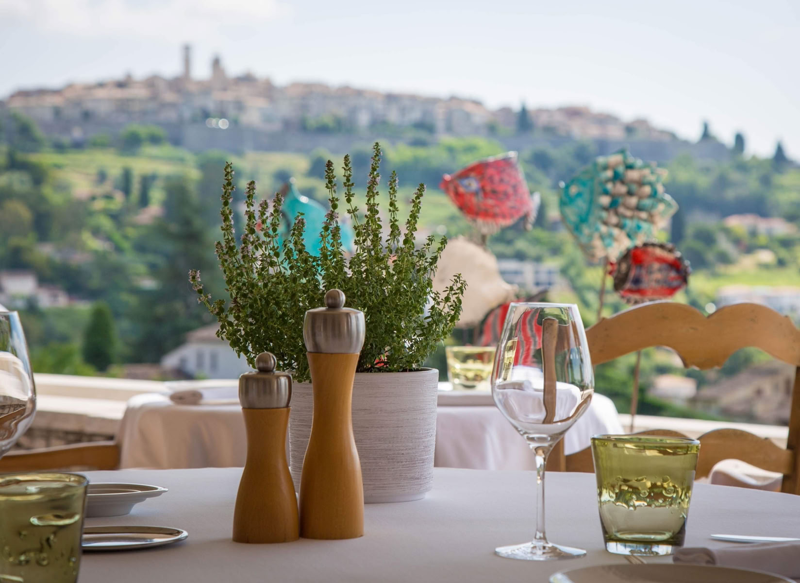 Le restaurant est perché à flanc de colline, à la Colle-sur-Loup, avec une terrasse panoramique offrant une vue spectaculaire sur Saint‑Paul‑de‑Vence et la Méditerranée.  L’espace mêle authenticité provençale et élégance chic : bastide en pierre, jardin soigné, grandes baies, voiturier, service professionnel mais décontracté .