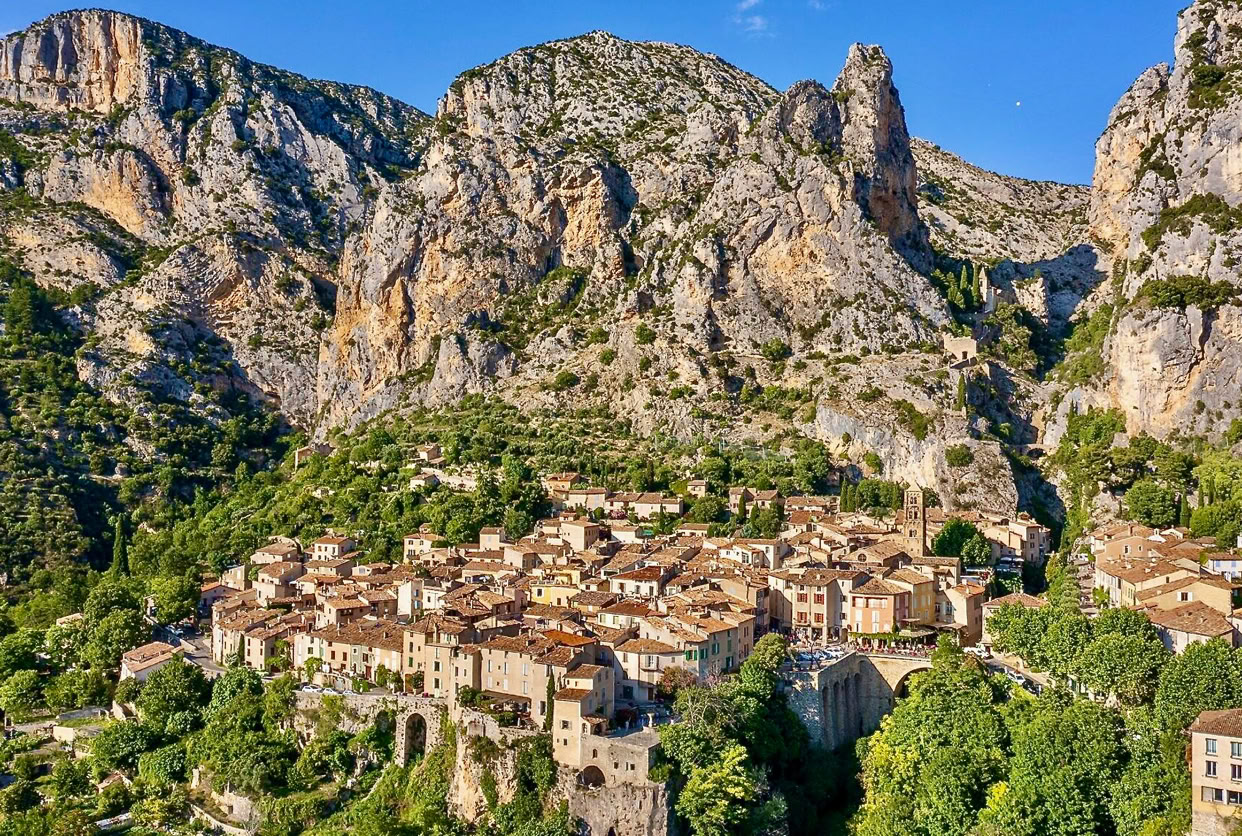 Situé au cœur des Alpes-de-Haute-Provence, Moustiers-Sainte-Marie est souvent considéré comme l’un des plus beaux villages de France.  Niché entre deux falaises et traversé par un petit torrent, ce village médiéval offre un décor de carte postale.