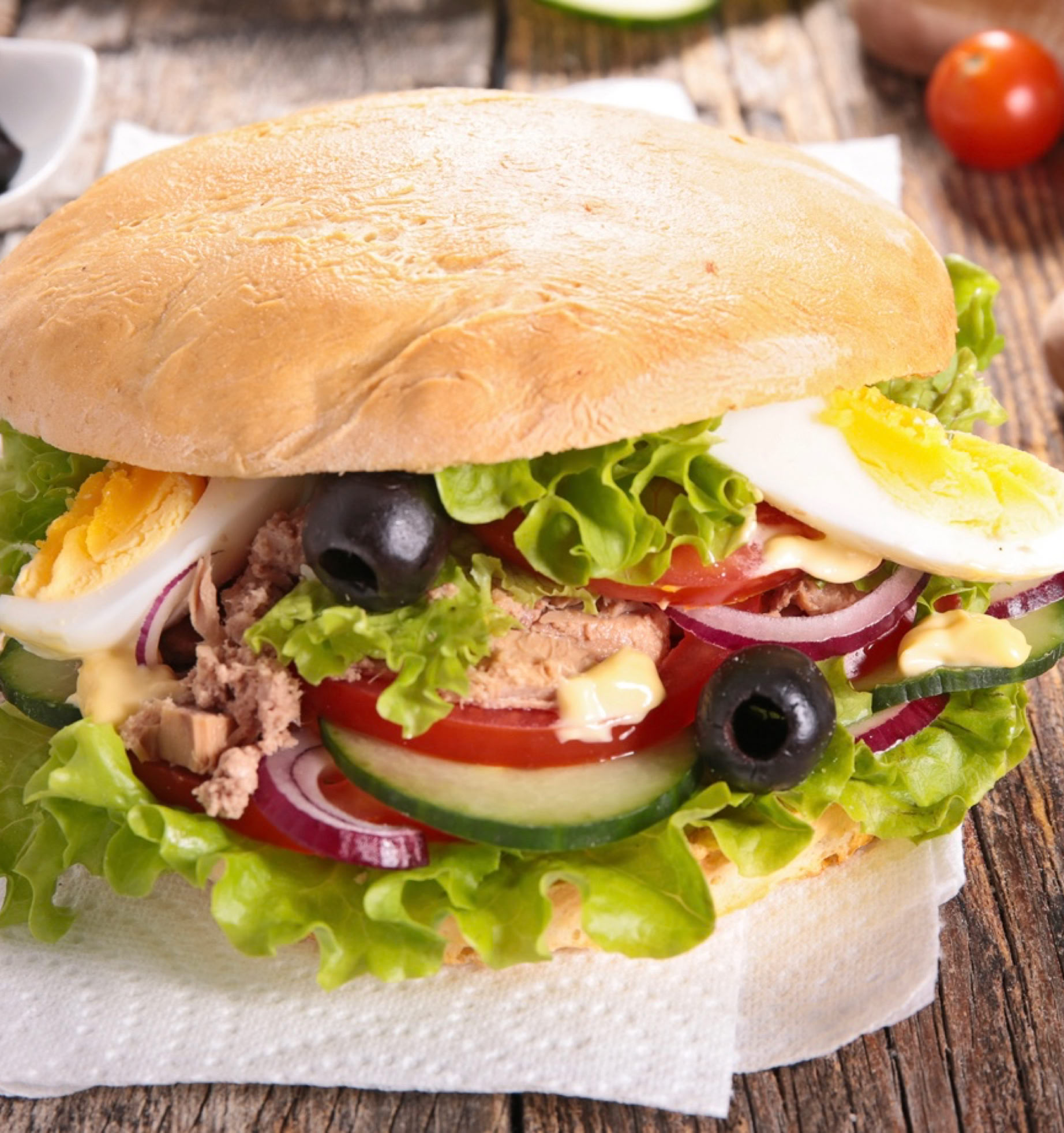 It’s an icon of Niçoise cuisine, simply the essence of the Niçoise salad... in a bread! A true street food, practical, complete, fresh, and deeply Mediterranean. "Pan bagnat" comes from the Niçard phrase "pan banhat," which means "wet bread." Originally, it was stale bread that was "wetted" with olive oil to make it tasty again. It’s a round bread (like country bread or pain bagnat bread) cut in half, filled with the ingredients of Niçoise salad, and especially without mayonnaise to stay true to tradition.