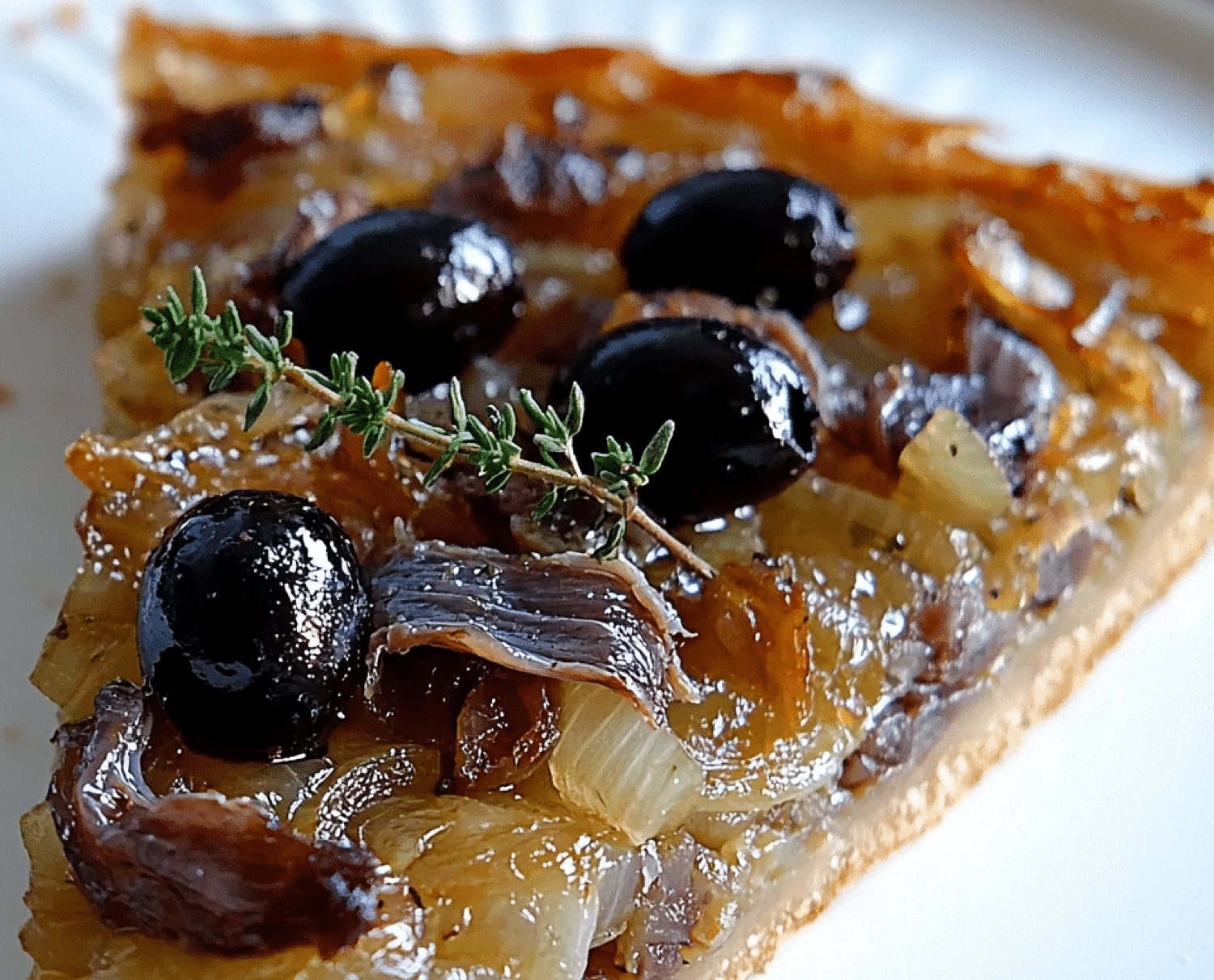 Another iconic specialty from the Nice region, and also widely enjoyed throughout Provence. It’s a kind of savory tart, somewhat similar to pizza, but with its own distinct character. It’s made with a bread dough or pizza dough base, generously topped with a sweet onion compote—slowly caramelized—along with anchovy fillets and black olives.